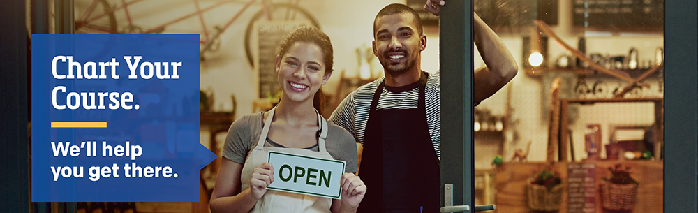 Couple holding open sign at store front