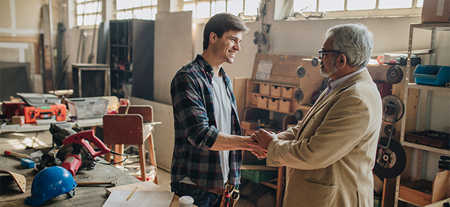 Man shaking hands with banker at construction site