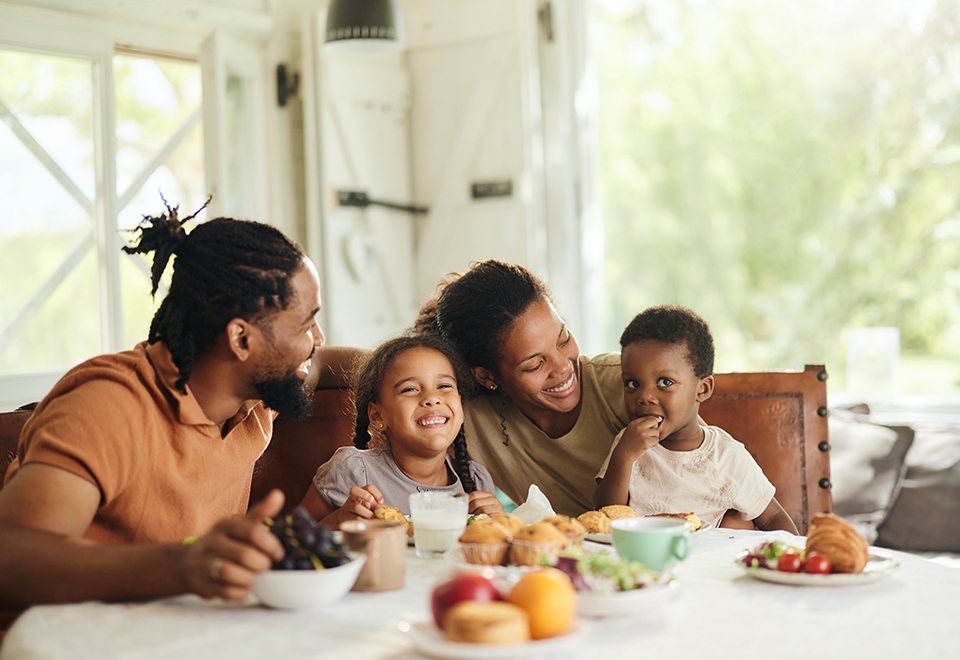 Home Equity - 960x660 – Chemung Canal Trust Company A family of four - two parents and two young children, sit at their table with breakfast in front of them