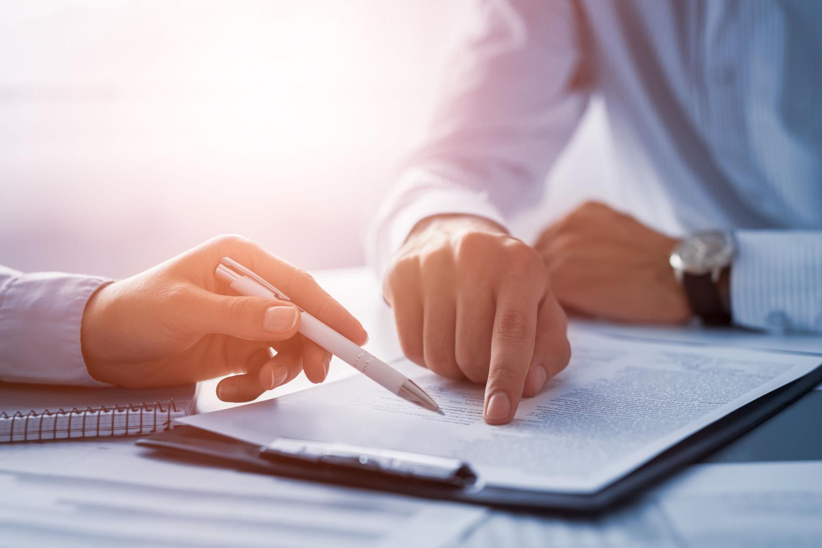 RSshutterstock_763046476 – Chemung Canal Trust Company Close of up hands, one hand is holding a pen pointing to a particular place in the paperwork