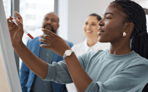A woman is writing on a pad of paper on the wall