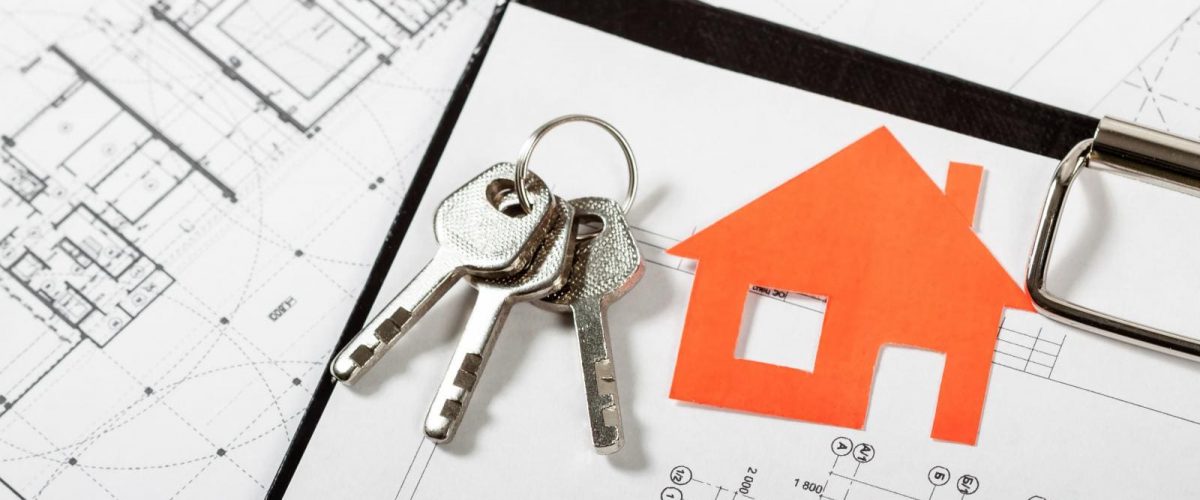 photo of a set of keys on a table on top of a home's blueprint drawings