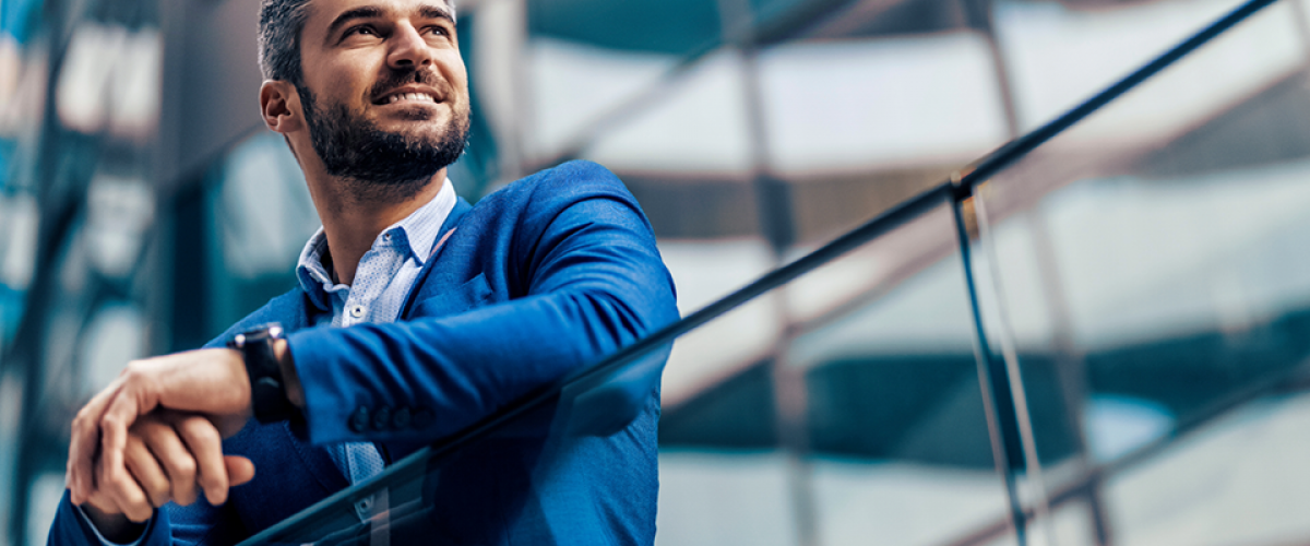 Prestige Banking – 960×660 A man in a suit stands at a balcony. He is looking off into the distance