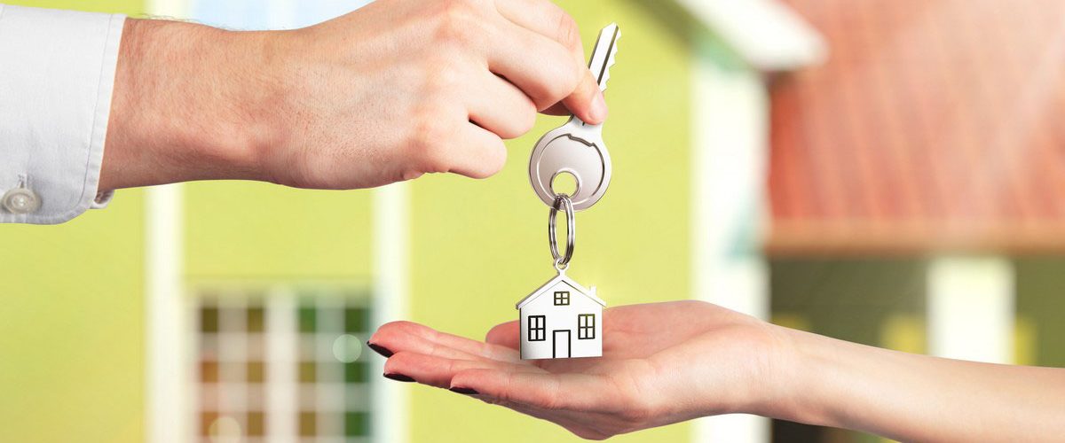 A photo of a person handing a house key to another person