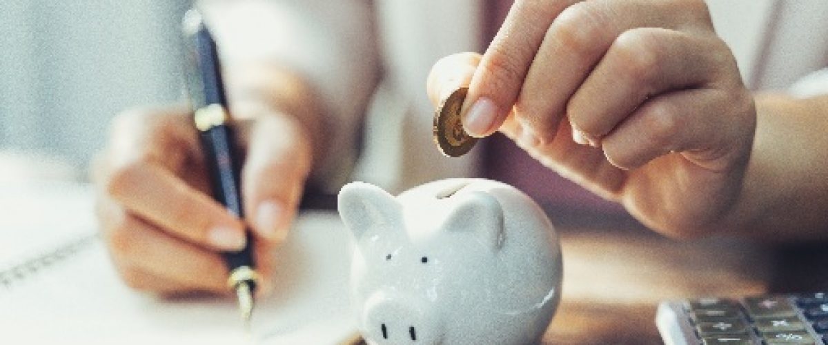 epmiSsKSoo1S9dFggB Woman putting change into a piggy bank