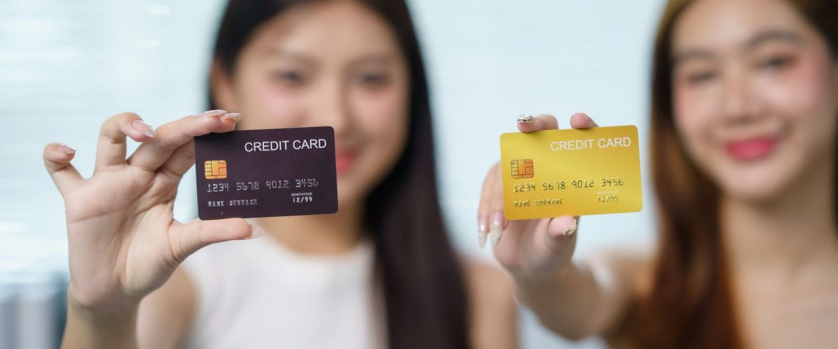 Women holding credit cards up to the camera