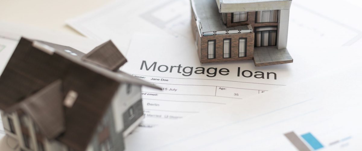 Mini houses on a paper titled "mortgage loan"